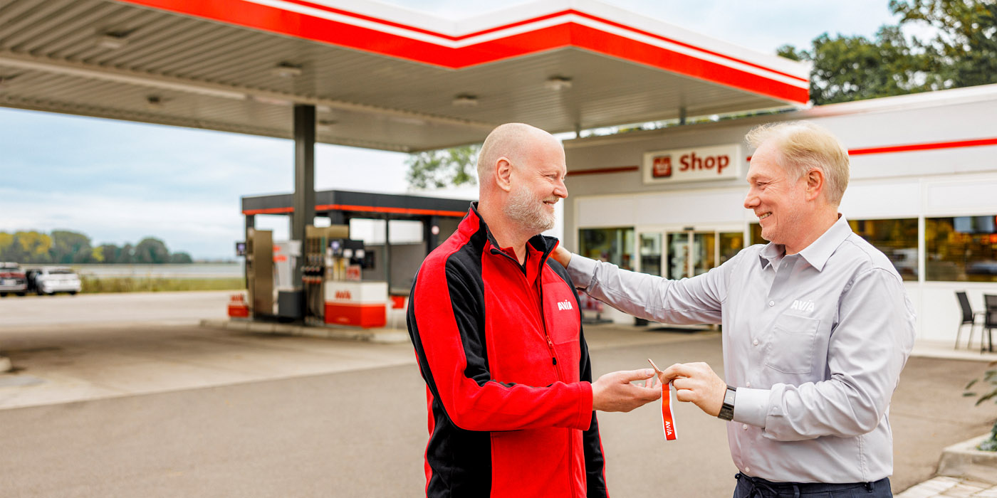 Schlüsselübergabe vor Tankstelle